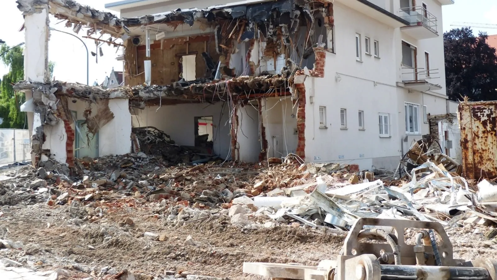 Pusiau nugriautas mūrinis namas su griuvenų krūva prie sienos